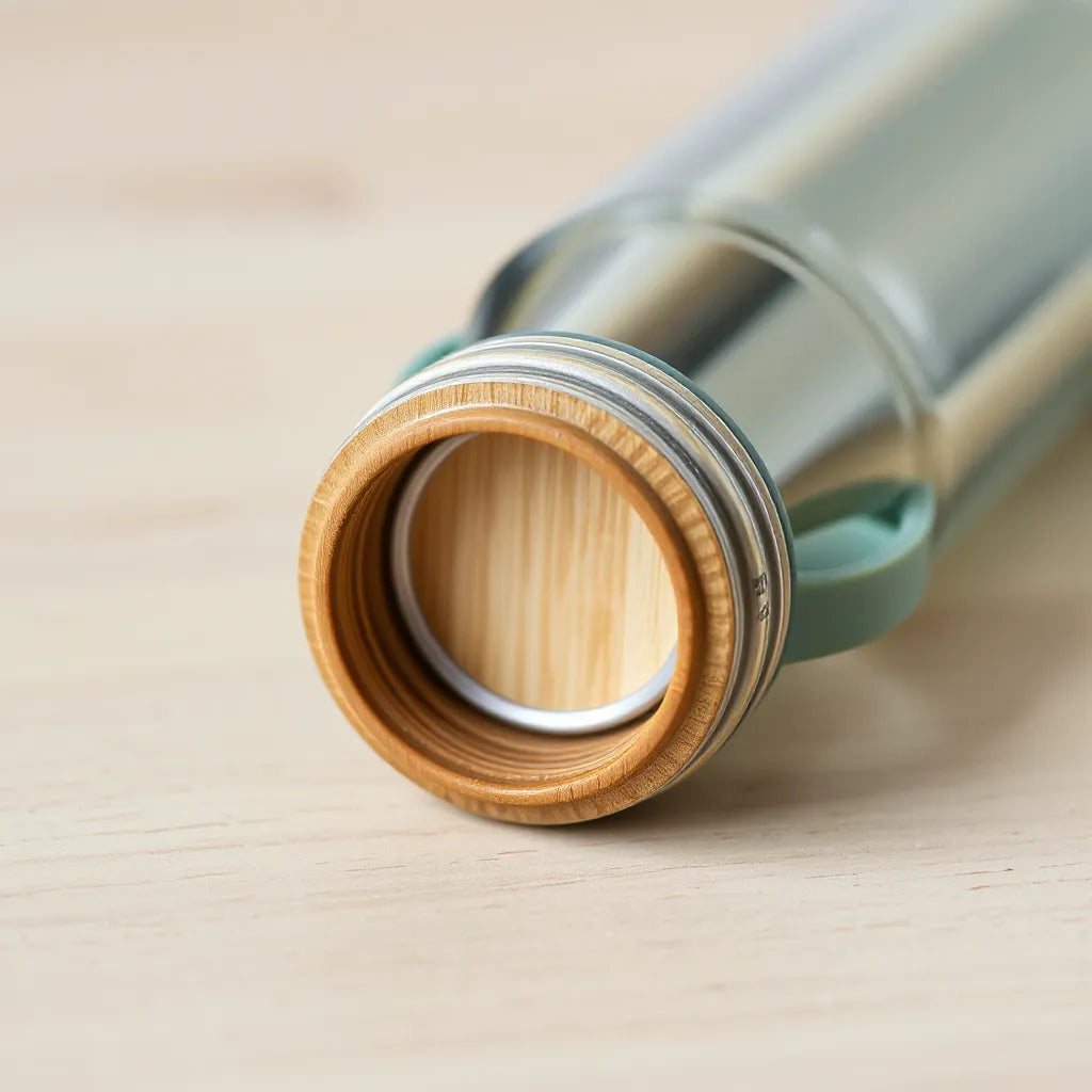 Bamboo water bottle top with silicone seal on a clean light wood surface