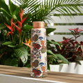 Copper Bottle with Mughal Floral Print on a wooden bench in a garden