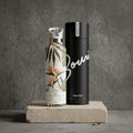 Malie 25 oz Insulated Bottle | Blue Hawaiian Floral on a cement background