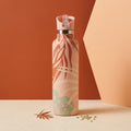 Ahe 25 oz Insulated Bottle | 3D Orange Palm in a burgundy and cream studio scene 
