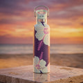 Nani 25 oz Insulated Bottle | 3D Jade Hibiscus atop a marble platform at a beach